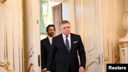 Robert Fico, învingătorul detașat al alegerilor din Slovacia cu partidul Smer, sosește la Palatul Prezidențial ca să depună jurământul ca premier, urmat de noul ministru al apărării, Robert Kaliňák. Bratislava, 25 octombrie 2023. (Foto: Reuters)