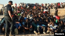 Polițiști spanioli și migranți africani la Ceuta pe 3 august 2026. Între timp, mulți dintre străinii pozați aici au fost convinși să plece.