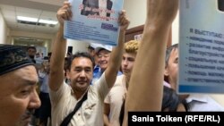 Активист Ербол Есхожин в коридоре суда с листовкой в поддержку активиста организации «Жер тағдыры» Кайырлы Омара. Нур-Султан, 2019 год.