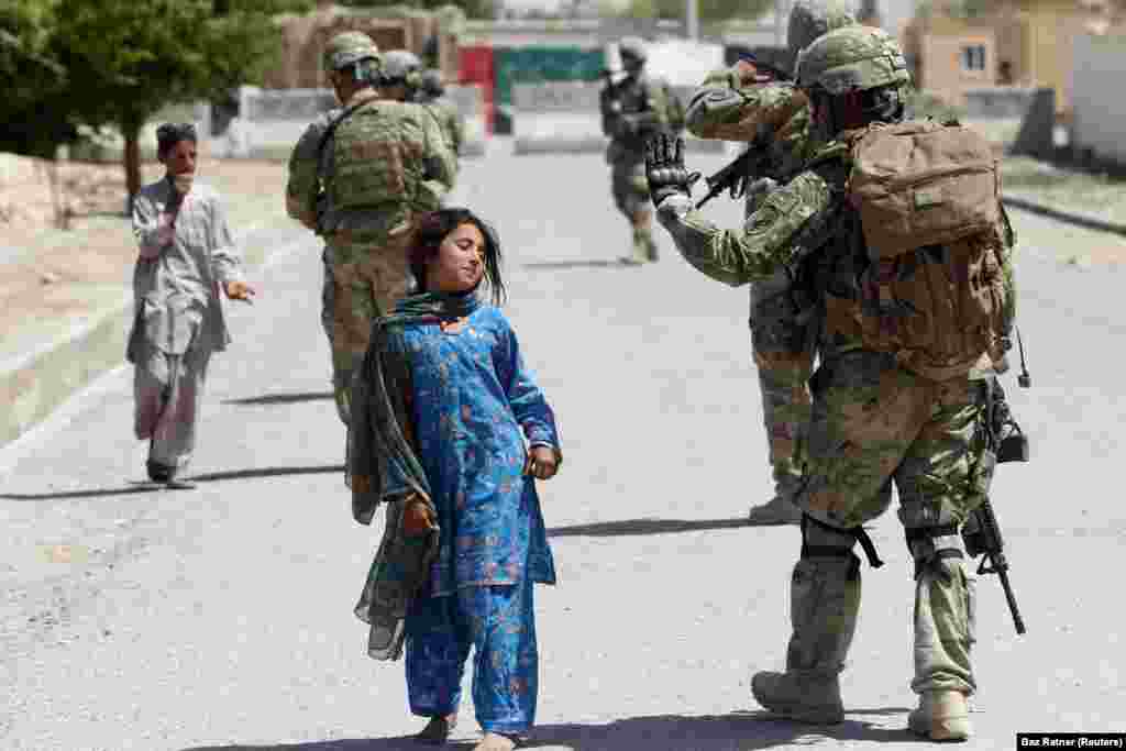 Devojčice prolazi pored američkog vojnika dok patrolira u provinciji Kandahar. (Hutal, 5. april 2012) &nbsp;