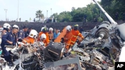 Na ovoj slici, koju je distribuirala malezijska vatrogasna i spasilačka služba, nekoliko radnika pregleda mjesto gdje su se srušila dva vojna helikoptera, u Lumuru, država Perak, 23. aprila 2024. 