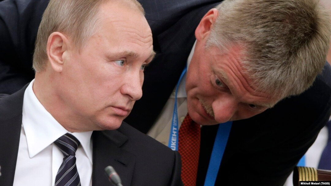 Russian President Vladimir Putin's spokesman, Dmitry Peskov (right), has been busy this week issuing nondenials on his boss's behalf. (file photo) 
