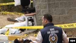 A forensics expert surveys the bloody scene outside the U.S. consulate