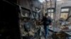 Resident Pavel gathers the belongings of his neighbor, who was killed in recent shelling, in his neighbor's house in Donetsk on December 10.