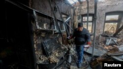 Resident Pavel gathers the belongings of his neighbor, who was killed in recent shelling, in his neighbor's house in Donetsk on December 10.