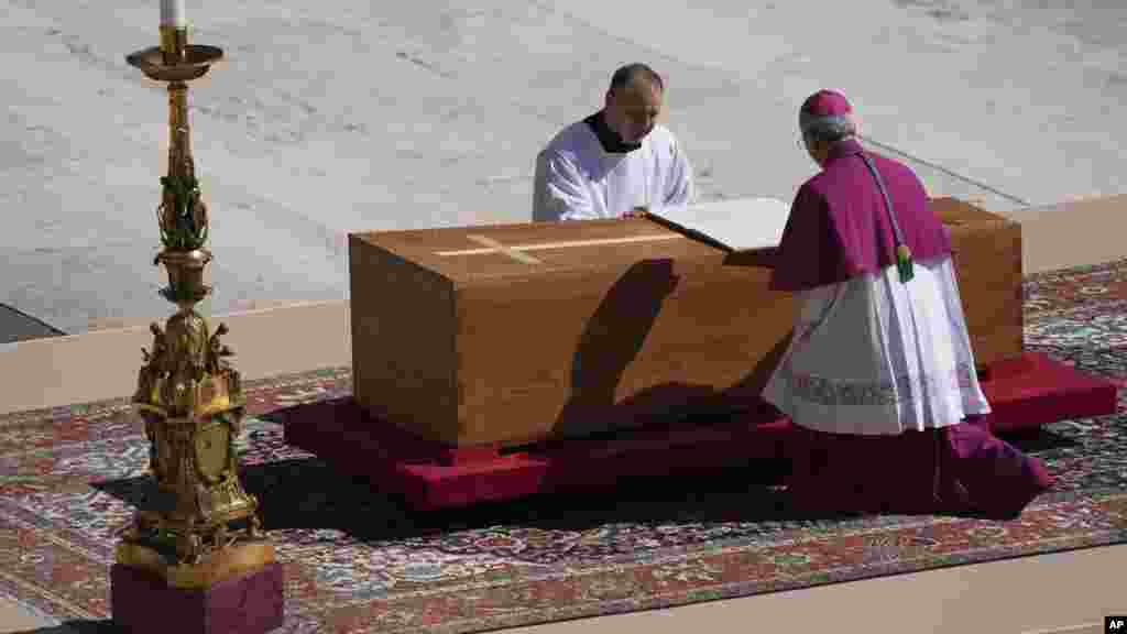 Arhiepiscopul Diego Giovanni Ravelli, îngenuncheat în dreapta, prezidează funeraliile Papei Francisc.