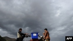 Afghan villagers load a donkey with election supplies for a village in the Panjshir valley ahead of the September 18 vote.