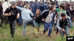 A video grab shows Petra Laszlo appearing to kick a child as she ran with other migrants from a police line during disturbances at Roszke in southern Hungary.