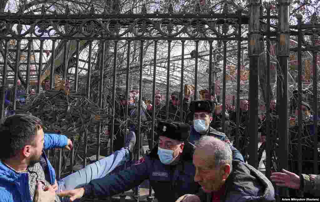 Police attempt to separate rival protesters. One of the men can be seen holding a rock.&nbsp;