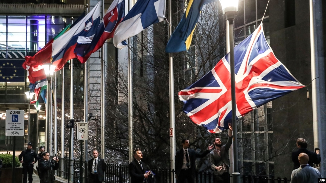 Служители на Европейския парламент свалят официалния флаг на Обединеното кралство от пилоните пред сградата в Брюксел, след като страната напусна ЕС в полунощ на 1 февруари 