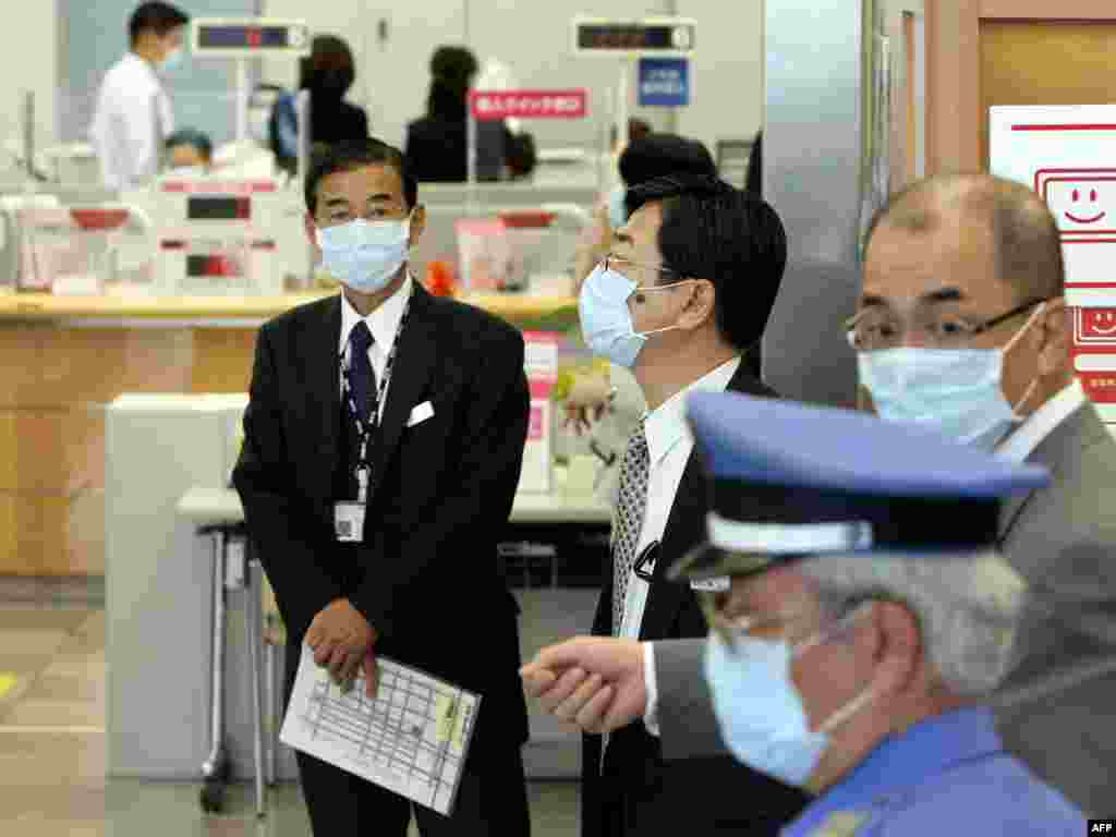 Japan - Maske potrebne? - Ovi zaposlenici banke u Kobeu su, nakon informacije da je jedan kolega inficiran virusom nove gripe, odlučili da maskama na licu povećaju mjere predostrožnosti. 
