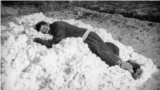 A collective farm worker rests on a pile of cotton. Photo by Max Penson.