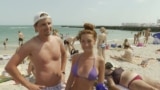 Ukrajinski turisti na jednoj od plaža u Odesi na Crnom moru, juli 2028.