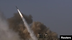 Members of Iran's Revolutionary Guard look at a surface to surface missile as it is launched during military exercises. 