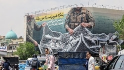 Iranac prolazi pored ogromnog bilborda s porukom "Hormuški moreuz ostaje zatvoren" na Trgu revolucije u Teheranu, 22. aprila.