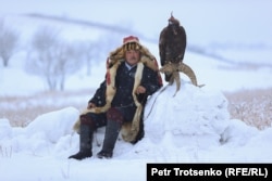 Egy berkucsi, vagyis egy sassal vadászó férfi megpihen madarával együtt Kazahsztánban december 5-én.