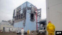 A Tokyo Electric Power Company handout photo of a worker spraying water to cool spent nuclear fuel at the reactor No. 4 building at Fukushima Daiichi nuclear plant (released on March 22).