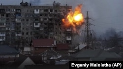 A Russian Army tank shell strikes an apartment building in Mariupol on March 11. The Ukrainian government has said at least 2,300 people have been killed in the besieged Azov Sea port city alone.