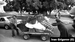 Мъж и жена теглят платформа на колела с части от техния бит. Капитан Андреево, 1989 г. Снимка: Иван Григоров.