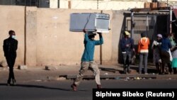 Čovjek trči nakon krađe u šoping centru tokom protesta koji su uslijedili poslije hapšenja bivšeg južnoafričkog predsjednika Jacoba Zume, Katlehong, 12. juli 2021. 