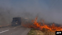 Cars drive along a burning field near Pokrovsk in Ukraine's eastern Donetsk region on September 16.