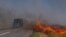 Cars drive along a burning field near Pokrovsk, Donetsk region, on September 16, 2024, amid the Russian invasion of Ukraine.