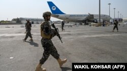 Taliban fighters are seen patrolling the airport in Kabul on August 31, one day after all U.S. troops withdrew.