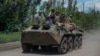 Ukrainian soldiers ride an armored vehicle on the front line near Bakhmut in the Donbas. 