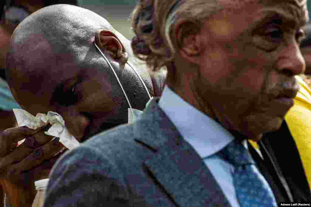 Reverend Al Sharpton is seen in the foreground as Philonise Floyd, brother of George Floyd, whose death in Minneapolis police custody has sparked nationwide protests against racial inequality, wipes tears after speaking during the public viewing of Floyd at The Fountain of Praise church in Houston, Texas, U.S., June 8, 2020.
