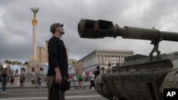 People visit an avenue where destroyed Russian military vehicles have been displayed in Kyiv in an exhibition dedicated to Ukraine's upcoming Independence Day on August 24.
