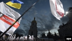 The flags of Joint Ukrainian Opposition wave above the crowd during their preelection meeting in front of St. Sophia Cathedral in Kyiv on October 26.