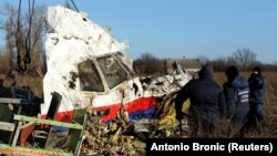 Local workers clear a piece of wreckage from Malaysia Airlines flight MH17 near the village of Hrabove after the plane was shot down over Ukraine in 2014, killing everyone on board. 