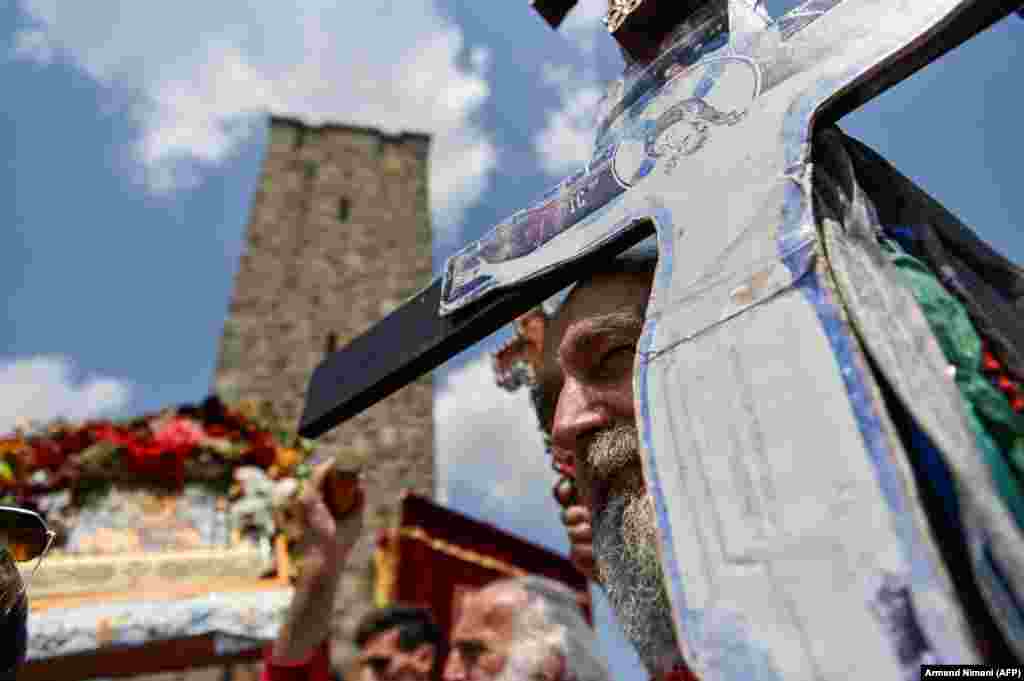 Сербы держат иконы у мемориала в Газиместане на окраине Приштины. Церемония приурочена к Битве на Косовом поле 1389 года, когда сербская армия потерпела поражение от Османской империи