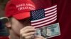 Дитина тримає доларову банкноту 2020 року з зображенням президента США Дональда Трампа