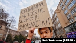 "Коронавирус, біз сенен қорықпаймыз!" деген жазуы ар плакат ұстаған жас жігіт. Алматы, 14 наурыз 2020 жыл.