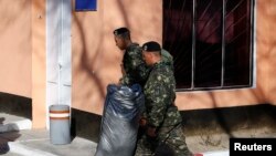 Ukraine -- Ukrainian marines carry personal belongings before departing Crimea, outside a Ukrainian military base in the Crimean port city of Feodosia, March 24, 2014