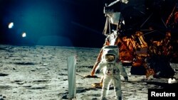 Astronaut Buzz Aldrin stands beside a solar wind experiment 