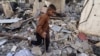 Момче се разхожда сред развалините на сграда след нощна израелска бомбардировка в Рафах в южната част на Ивицата Газа на 25 март 2024 г.