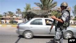 An Iraqi policeman stands guard at a checkpoint in central Baghdad. It's feared that suicide bombers are able to use army uniforms to pass through such checkpoints.