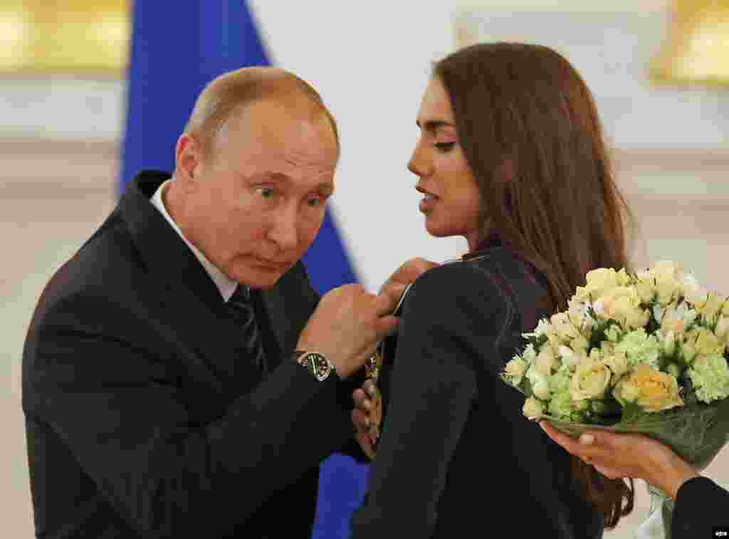 Vladimir Putin, înmânându-i o distincție campioanei mondiale și olimpice de gimnastică ritmică Margarita Mamun, la Kremlin, august 2016