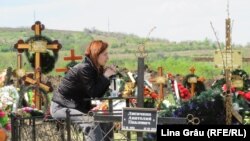 O tânără la un mormânt proaspăt, în zona „sectorului nou” al cimitirului Sfântul Lazăr din Chișinău, de Paștele Blajinilor. Mormintele proaspete sunt din perioada pandemiei de Covid-19.