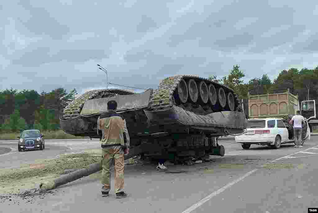An overturned tank is pictured on a road near the Russian village of Troitskoye. The tank fell off a tractor truck.