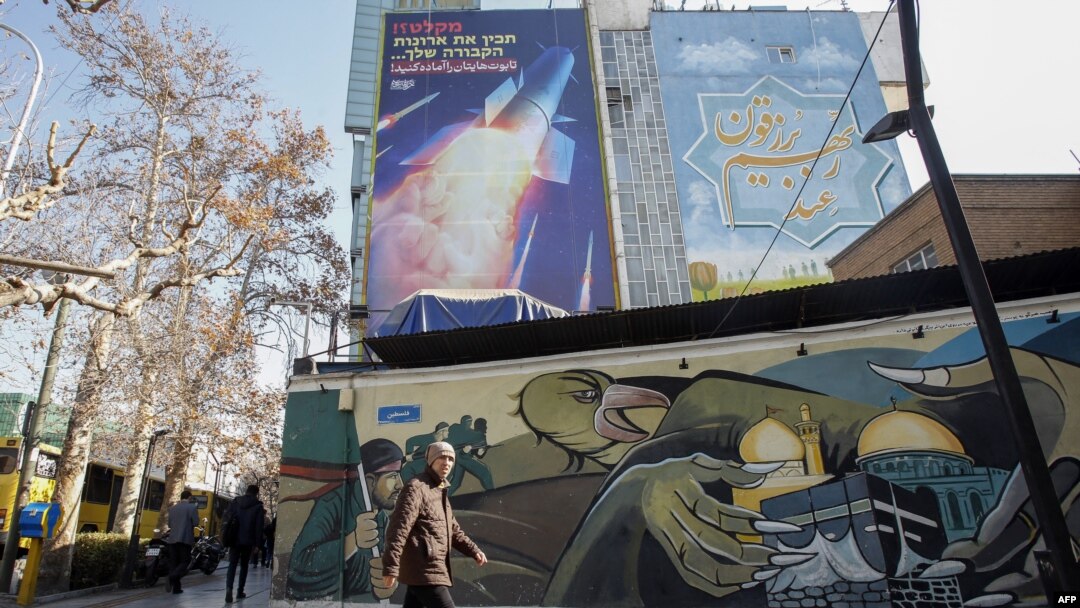 A billboard depicting an Iranian missile with a phrase in Persian that reads "Prepare your coffins" hangs on the side of a building in Tehran on January 16.