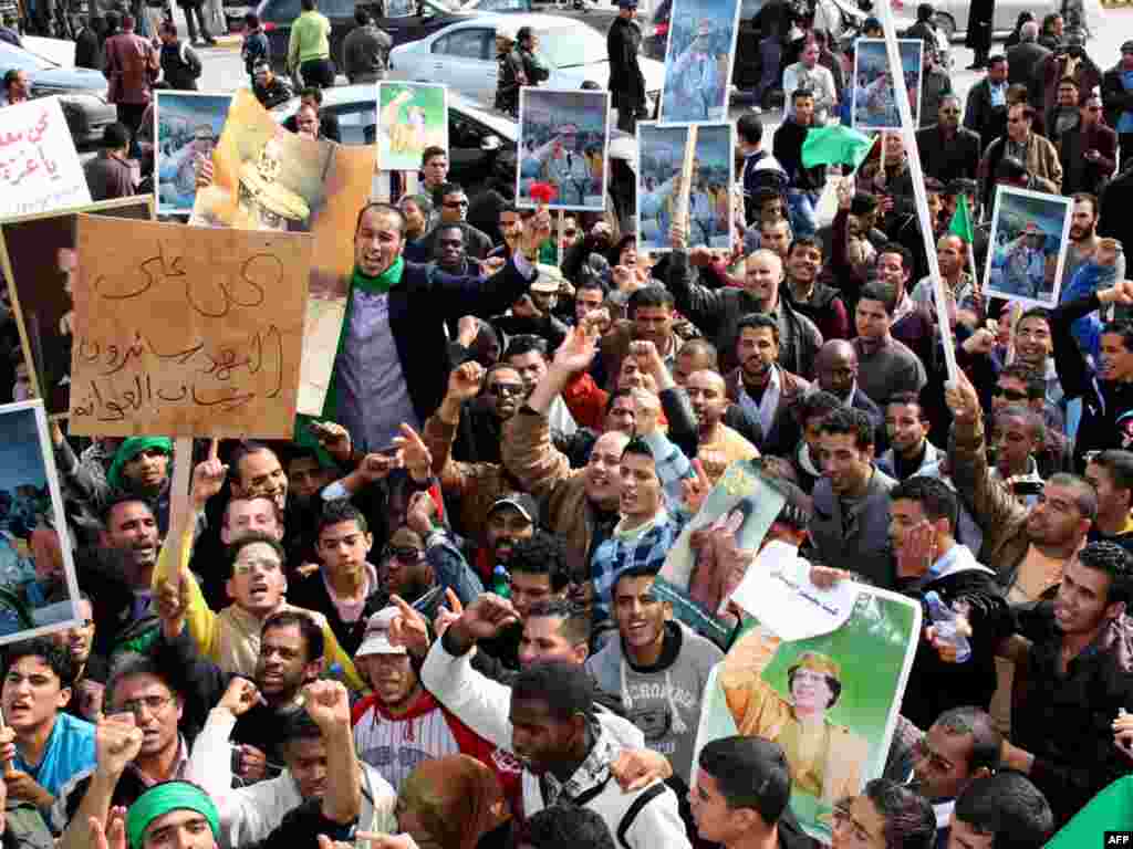 Либија - про-владини демонстрации - LIBYAN ARAB JAMAHIRIYA, Tripoli : Libyan pro-government supporters hold portraits of leader Moamer Kadhafi during a gathering in Tripoli on February 16, 2011 to show support for the veteran leader who seized power in a 1969 coup, as Libya braced for a "Day of Anger" following revolts in neighbouring Egypt and Tunisia. TOPSHOTS/AFP PHOTO/MAHMUD TURKIA 