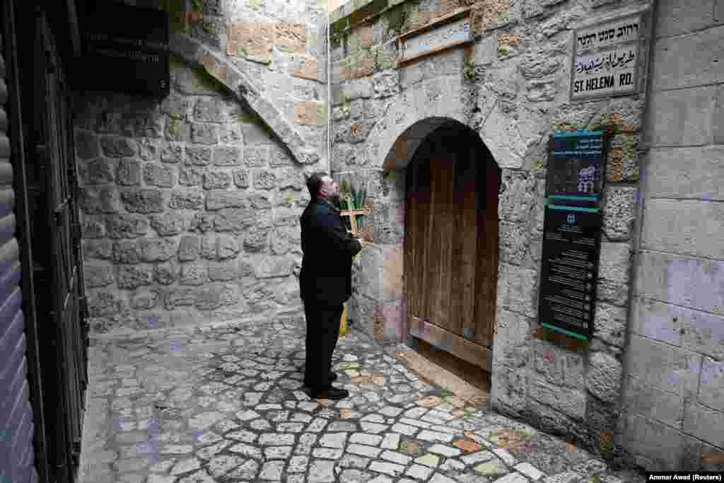 A Palestinian Christian man at the locked doors of the Church of the Holy Sepulchre in Jerusalem on March 29.Access to the church, which is widely viewed as the holiest site in Christianity, was blocked by Israeli authorities on Palm Sunday amid restrictions on large gatherings during the war with Iran. The holy site was later reopened to worshipers following widespread criticism of the closure.