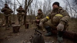 Câțiva membri ai armatei ucrainene se odihnesc lângă poziția lor de pe linia frontului din regiunea Donețk, Ucraina, 1 ianuarie 2023.