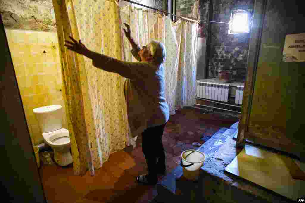 Residents share communal toilets, separated by flimsy shower curtains, and the ceilings are black with mold.