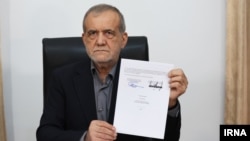مسعود پزشکیان با صفحه پایانی تفاهم‌نامه که امضای ترامپ (خط سیاه) و خود او را دارد