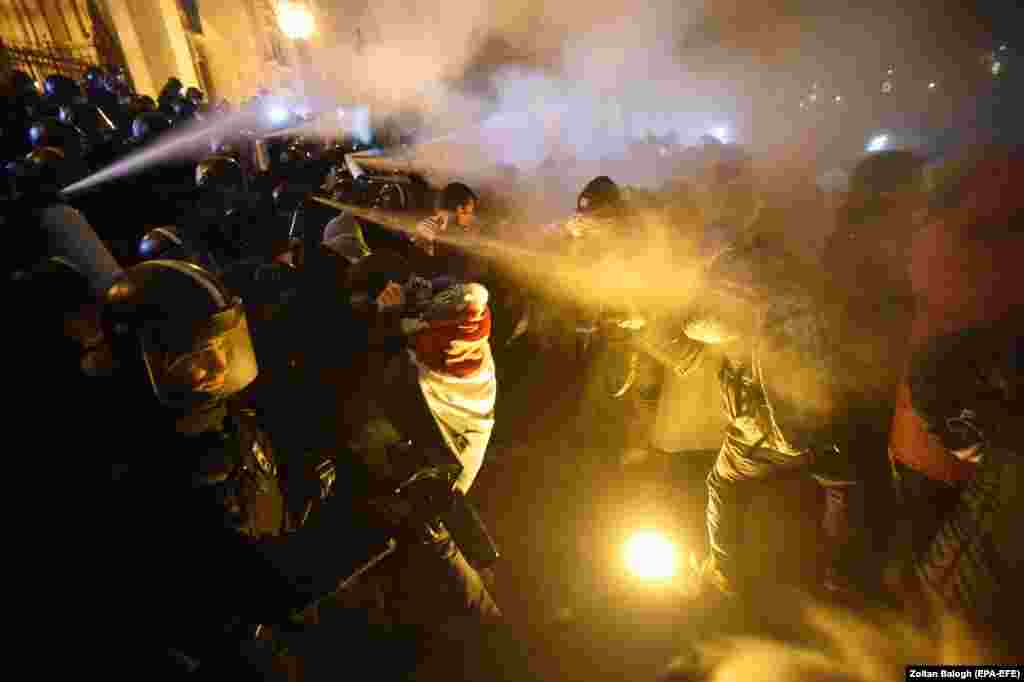 Protesters clash with police during a demonstration against amendments to Hungary&#39;s Labor Code outside the parliament building in Budapest on December 13. (epa-EFE/Zoltan Balogh)