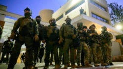 د امریکا فېډرالي او د کورني امنیت وزارت سرتېري د اورېګان ایالت په پورټلینډ کې د کډوالۍ او ګمرکي چارو ادارې ودانۍ مخې ته ولاړ دي - د اکتوبر شپږمې انځور. 